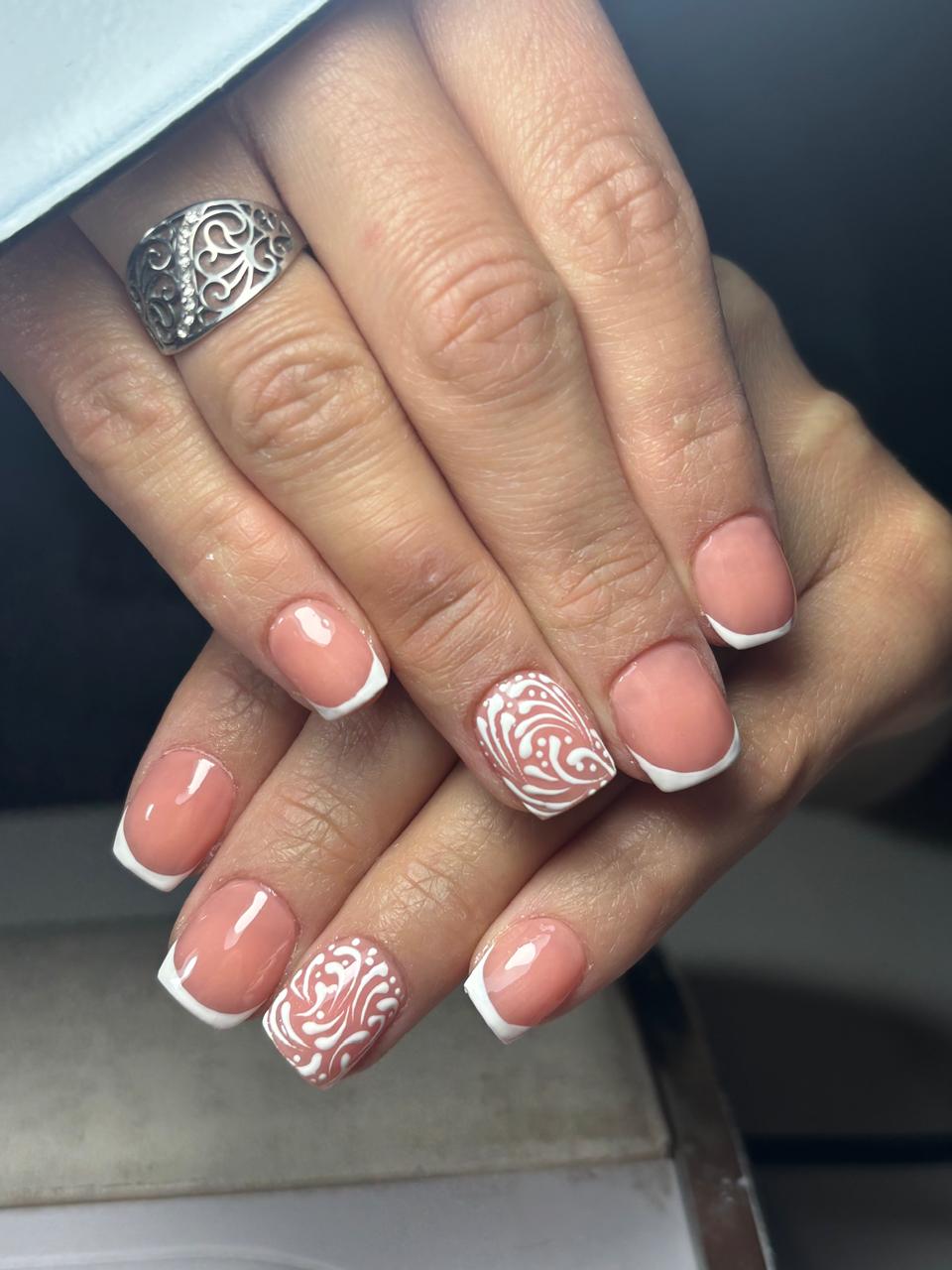 Uñas esculpidas francesitas con diseño arabesco blanco