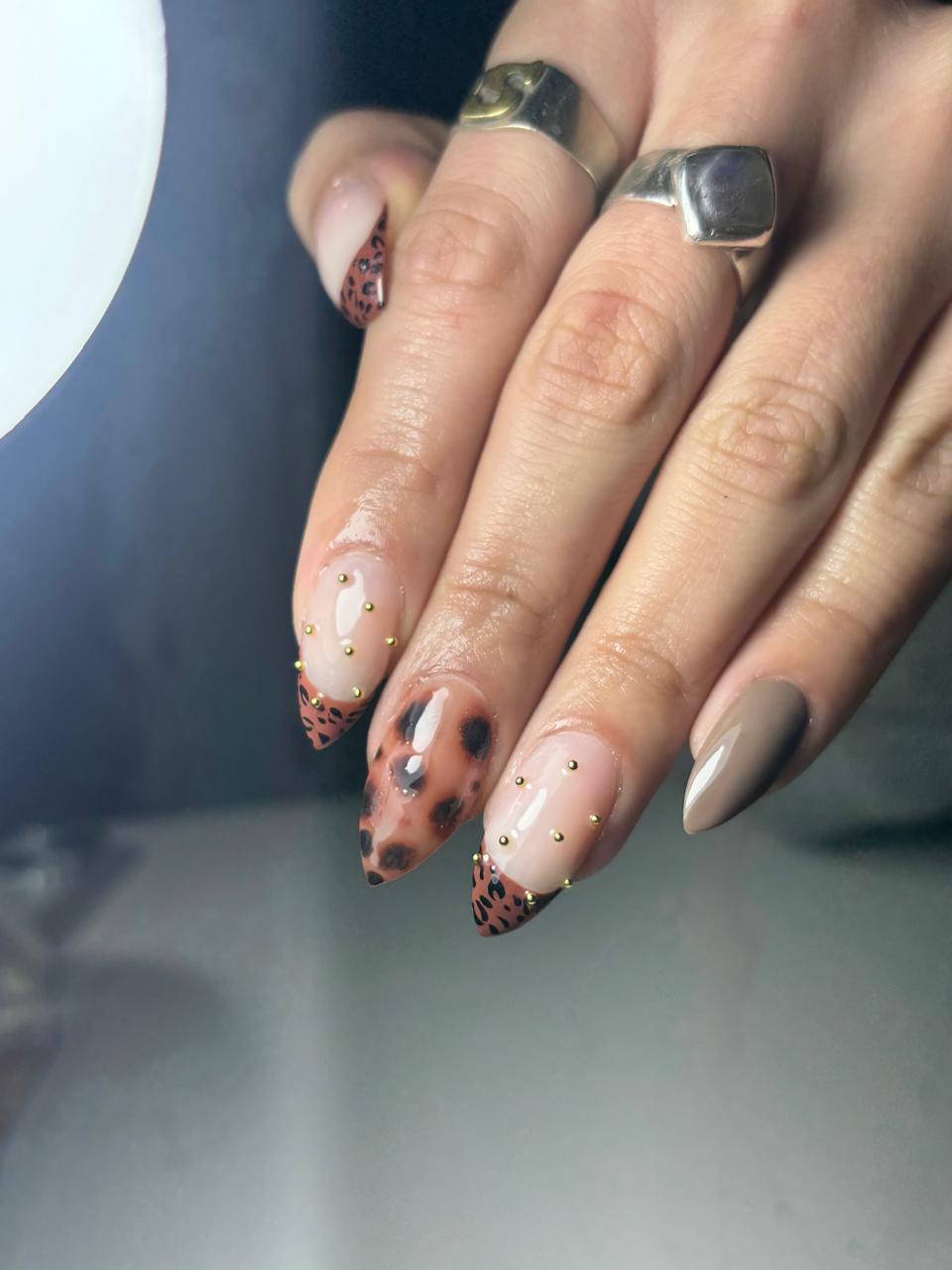 Uñas almendradas nude con francesa animal print y apliques dorados